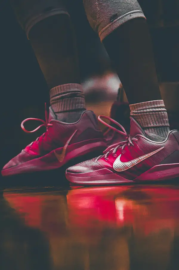 Close-up of red basketball shoes reflected on a glossy floor