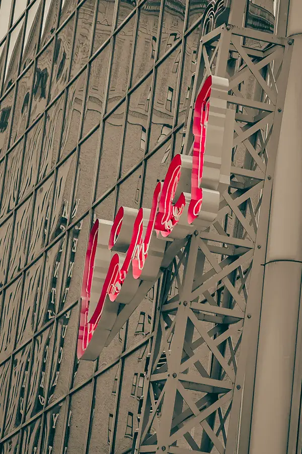 Neon cursive sign on a steel-framed building