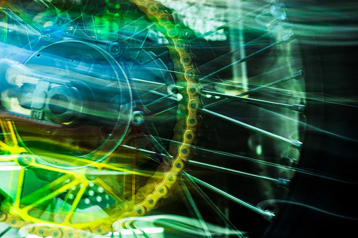 Motorcycle wheel streaked with green and yellow light trails