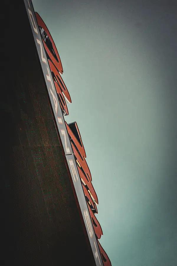 Tilted shot of a dark sign against a pale sky