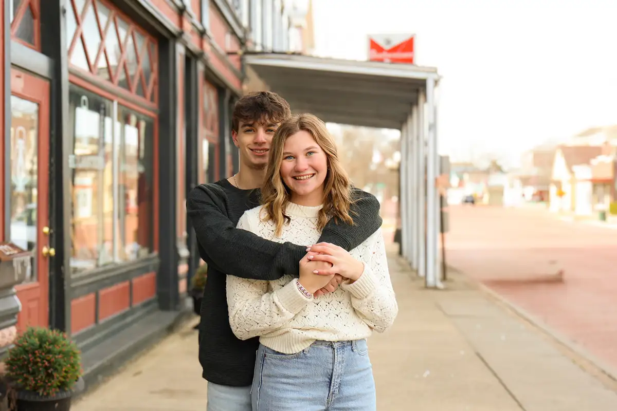 Couple hugging outside a storefront downtown